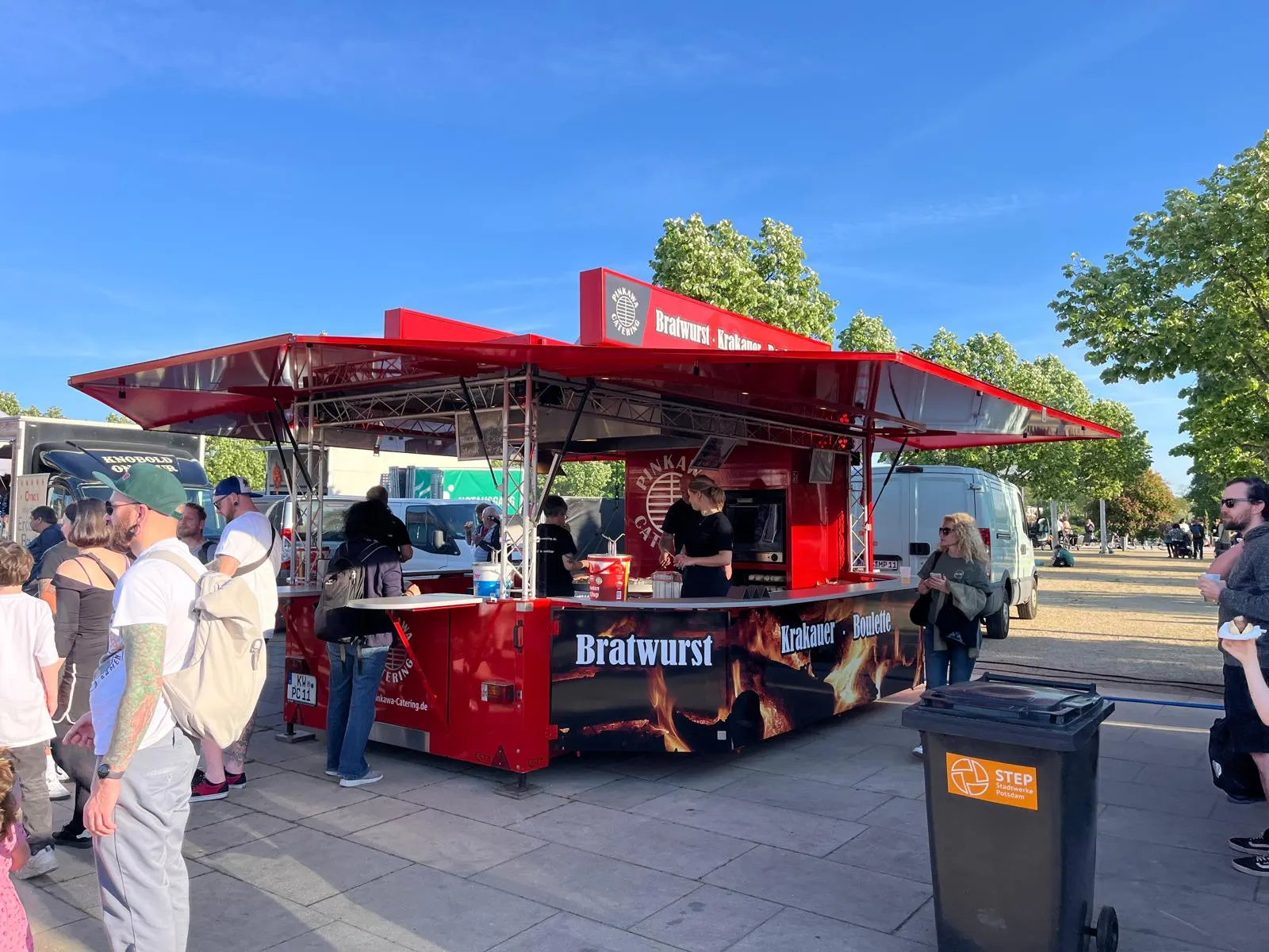 Der rote Grillwagen von Pinkawa Catering auf einem Stadtfest, davor eine Schlange von Gästen