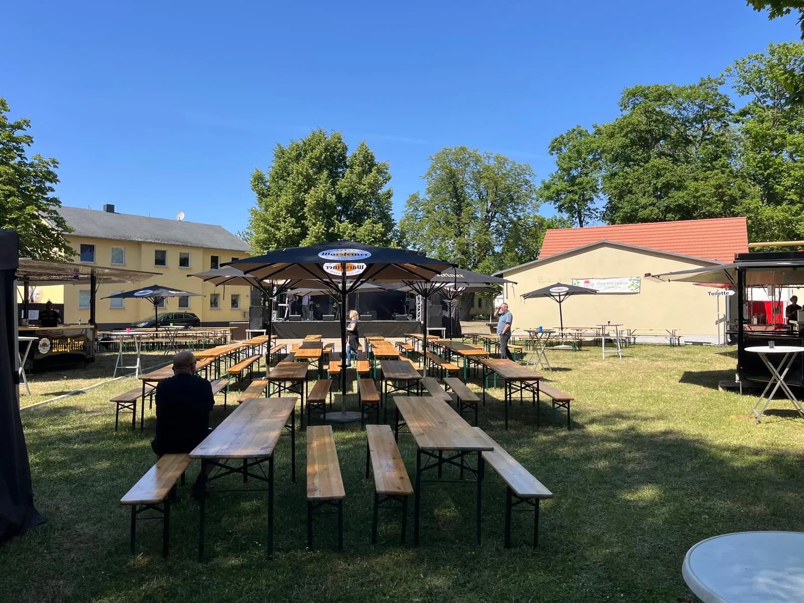 Festgelände mit langen Reihen von Biergarnituren